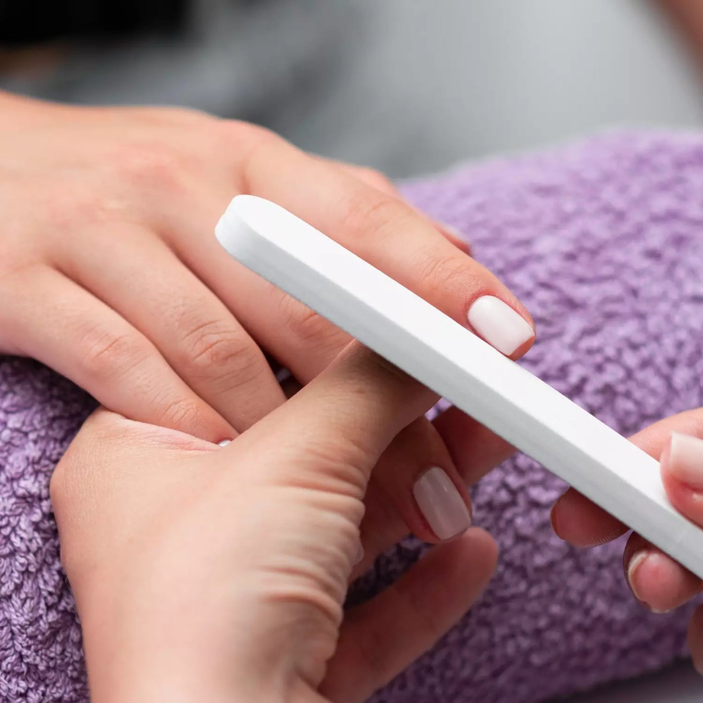 Professional nail file with white handle and grey sanding surface