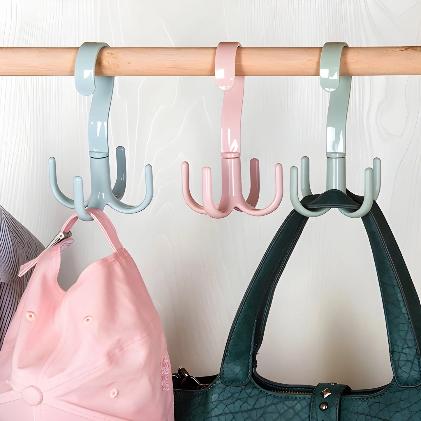 360° rotating bag hanger with teal hooks on bar, holding a dark green handbag