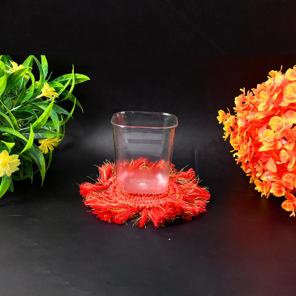 Clear glass tumbler with red fringed decorative base