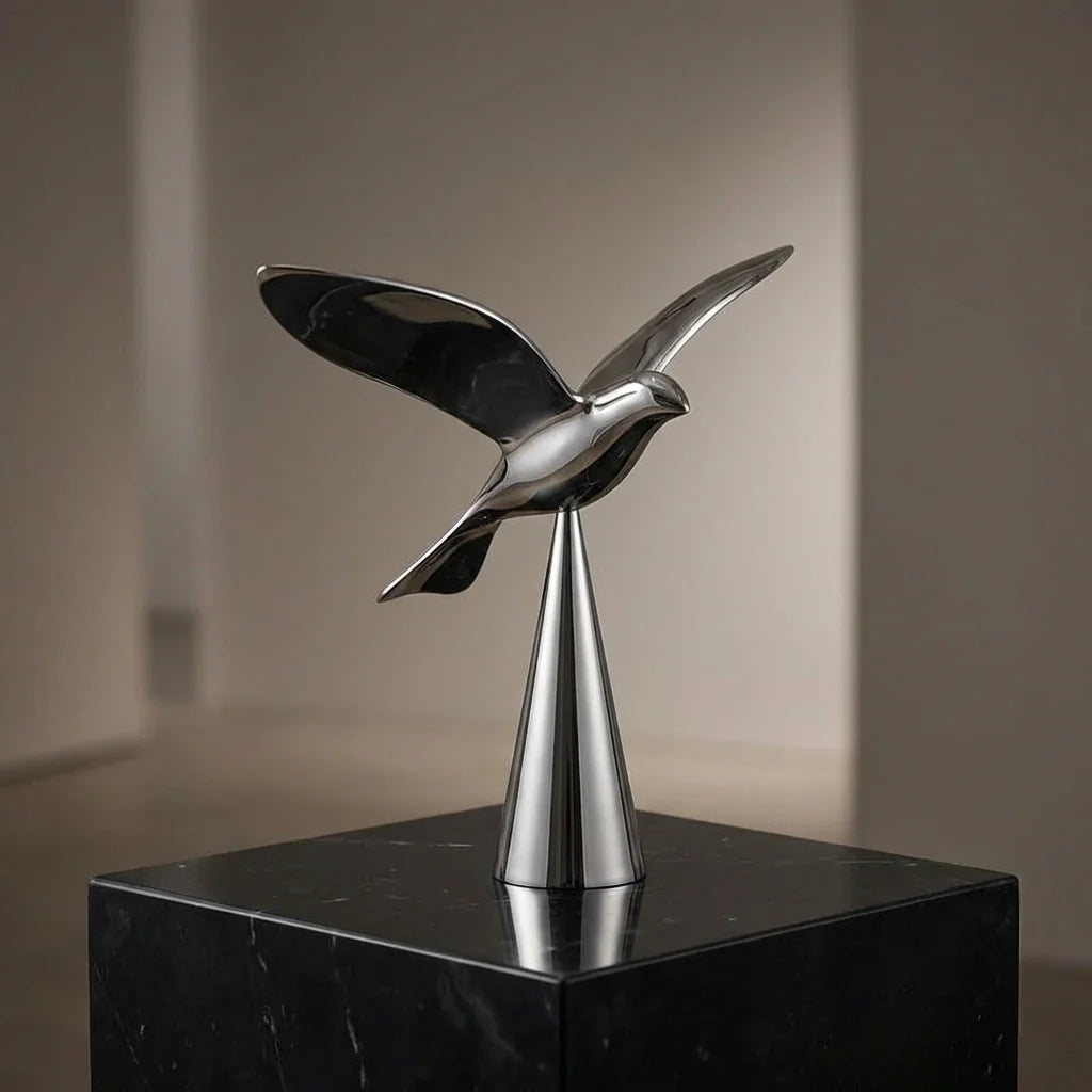 Metal bird bottle opener with curved wings and pointed tail, polished silver finish.