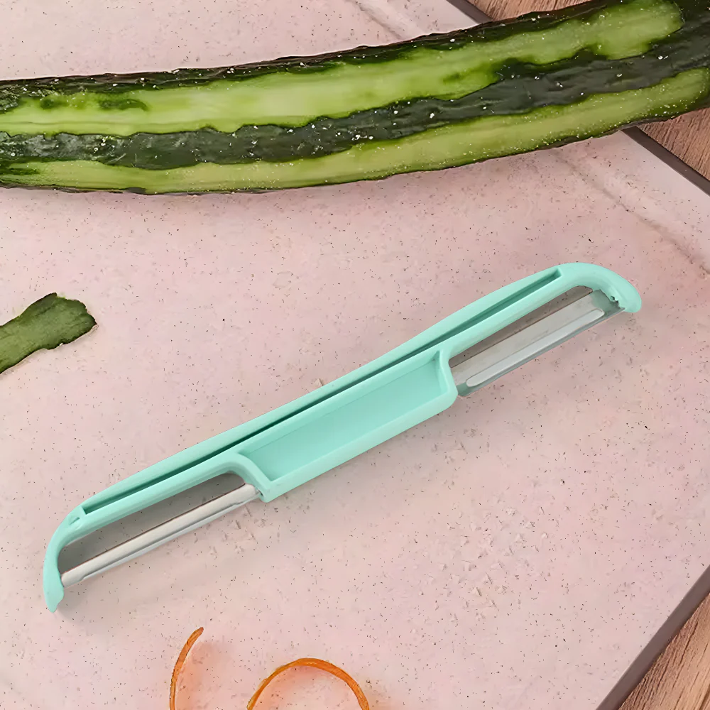 Turquoise double-sided veggie peeler with metal blades, beside a green cucumber
