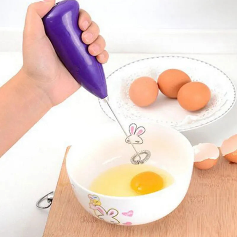 Purple electric hand blender with blending shaft over bowl of eggs