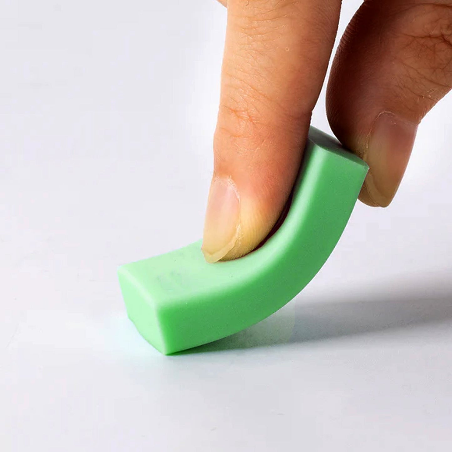 Green rectangular eraser held between fingers