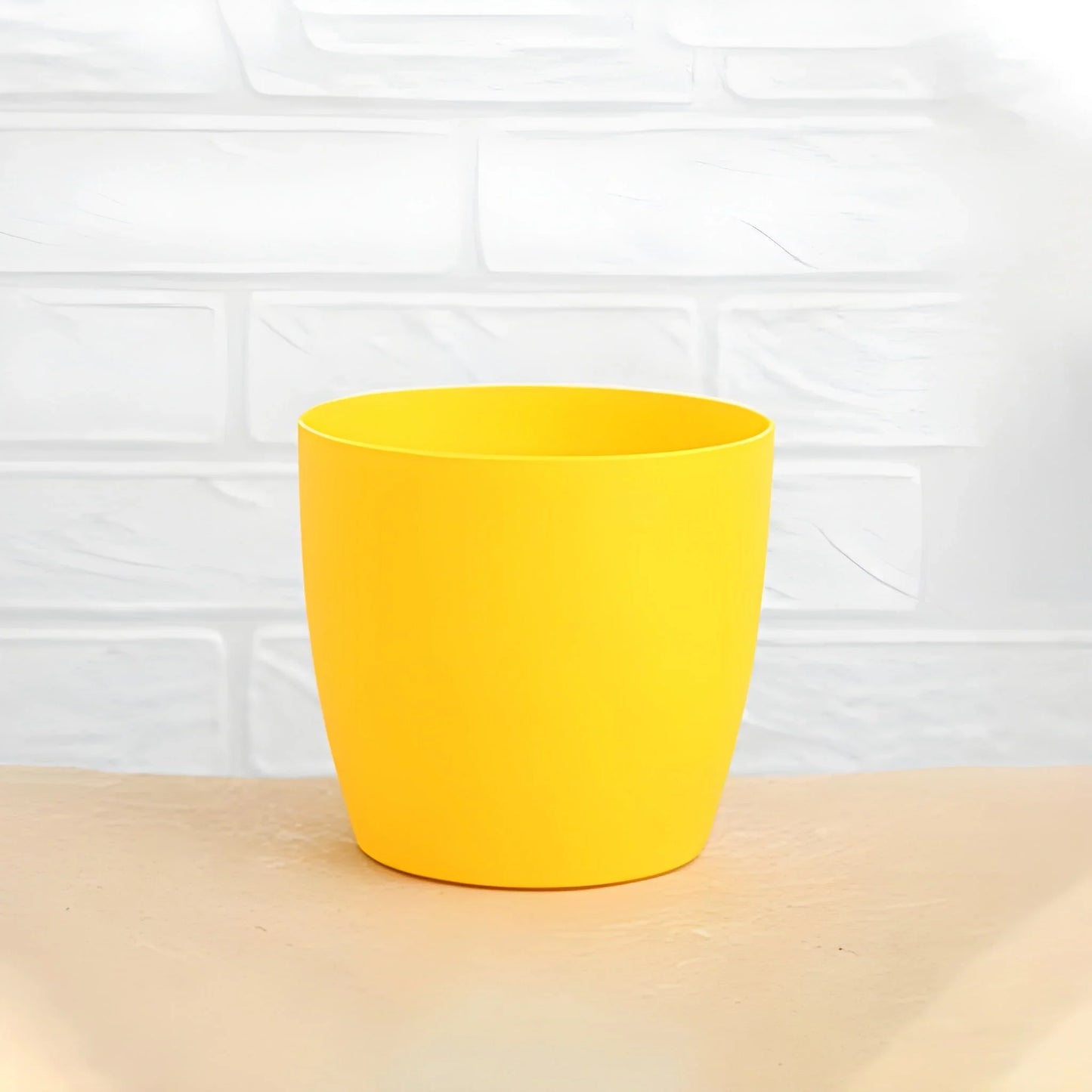 Round flower pot in solid yellow with smooth sides