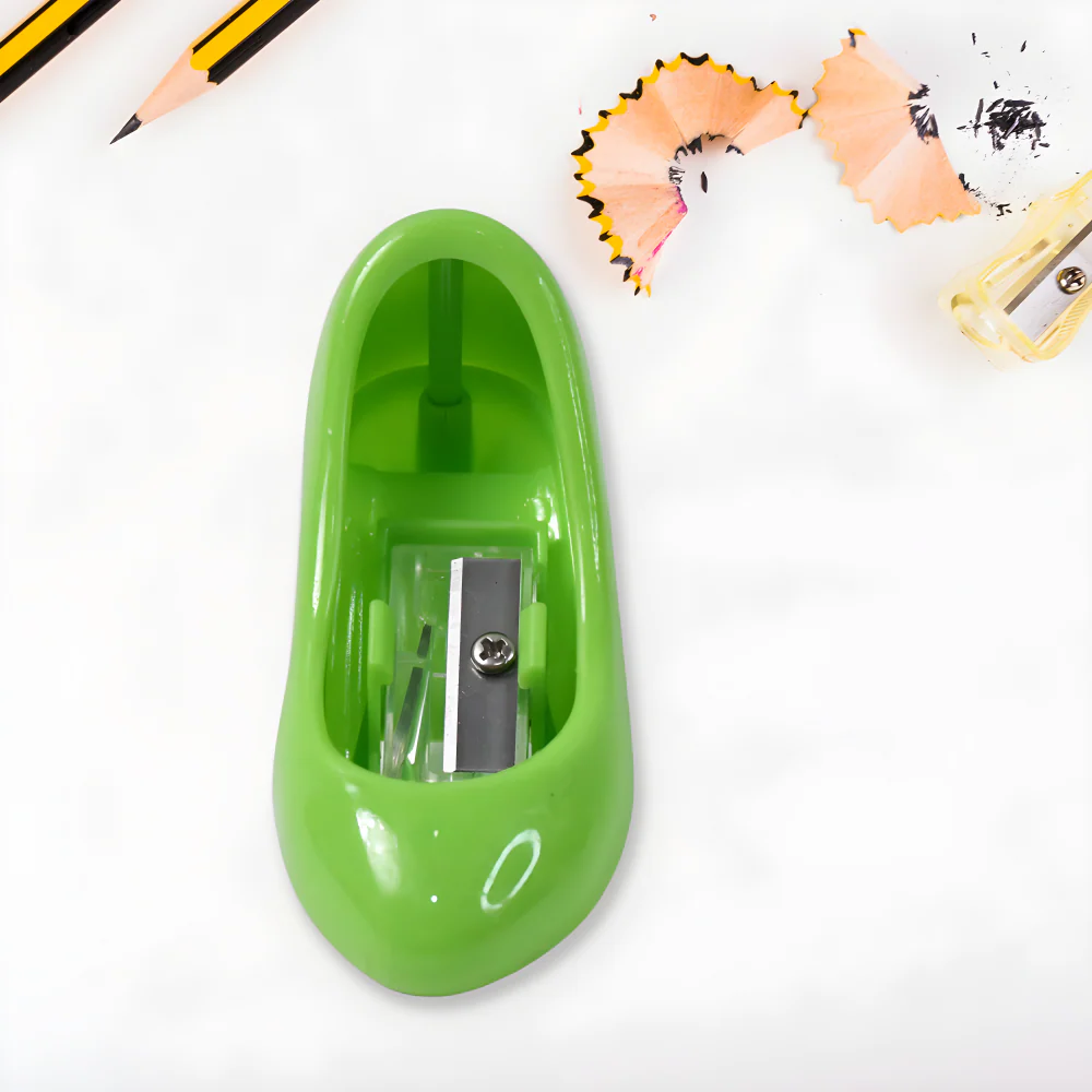 Green plastic pencil sharpener with exposed metal blade and crank window