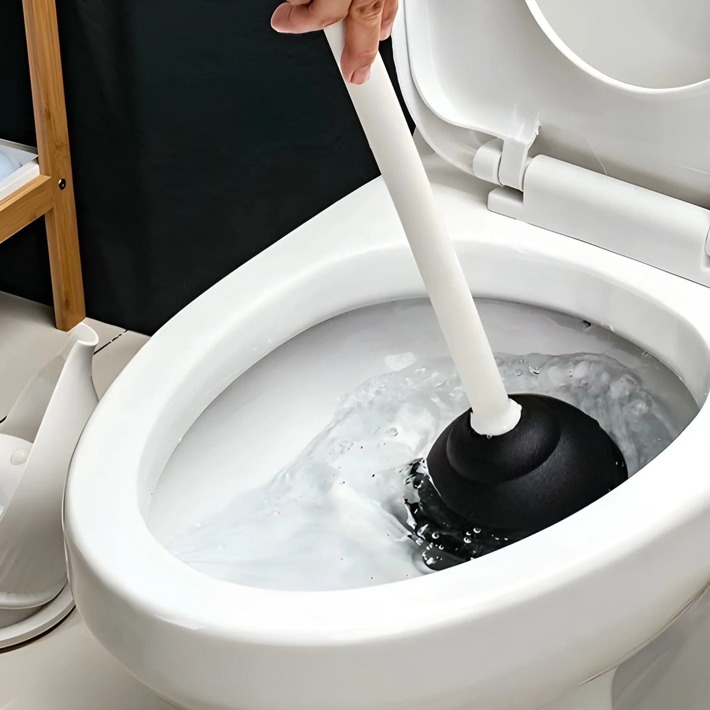 Drain plunger inserted into toilet bowl drain with plunger head submerged