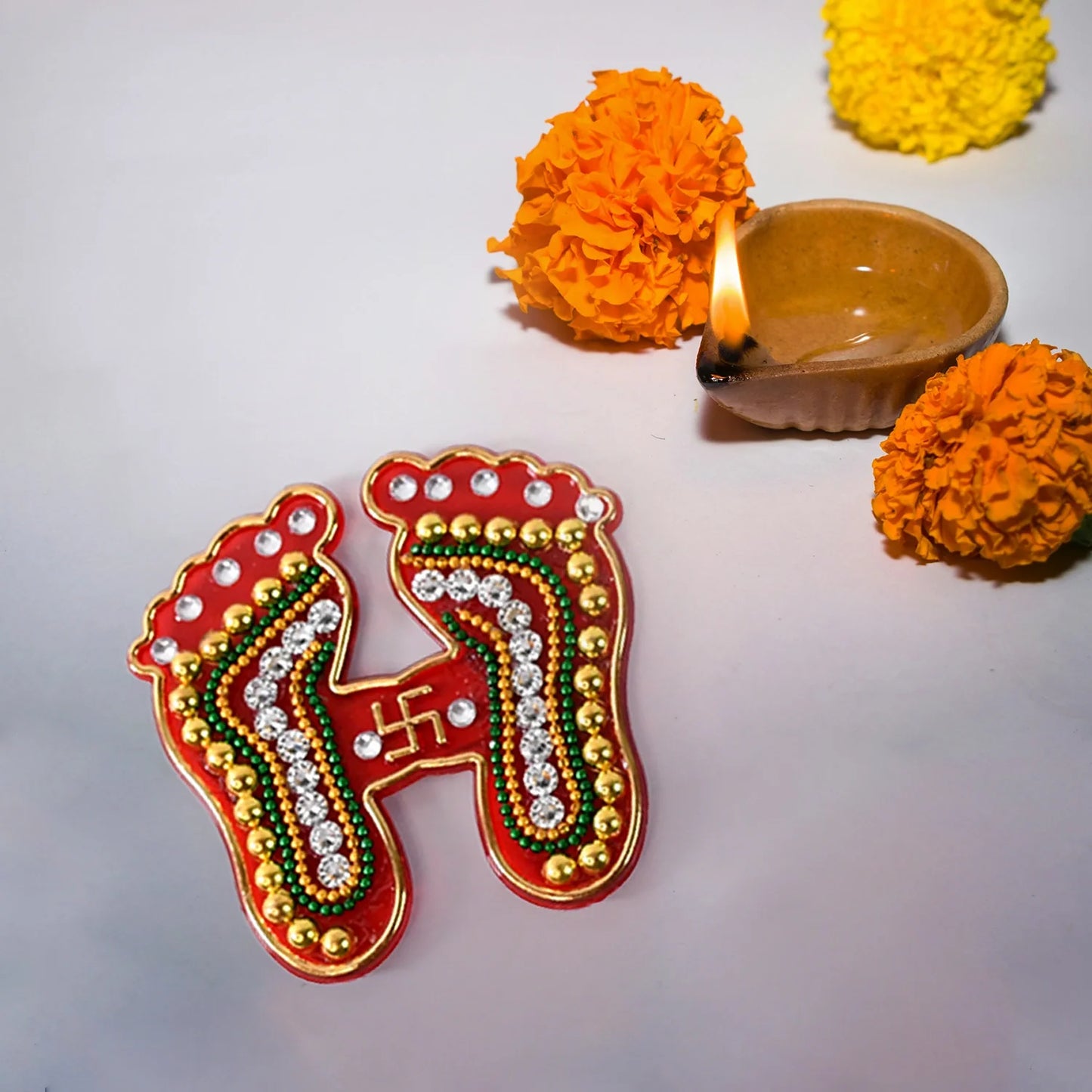 Decorative footprint-shaped sticker with red, gold and green beadwork accents
