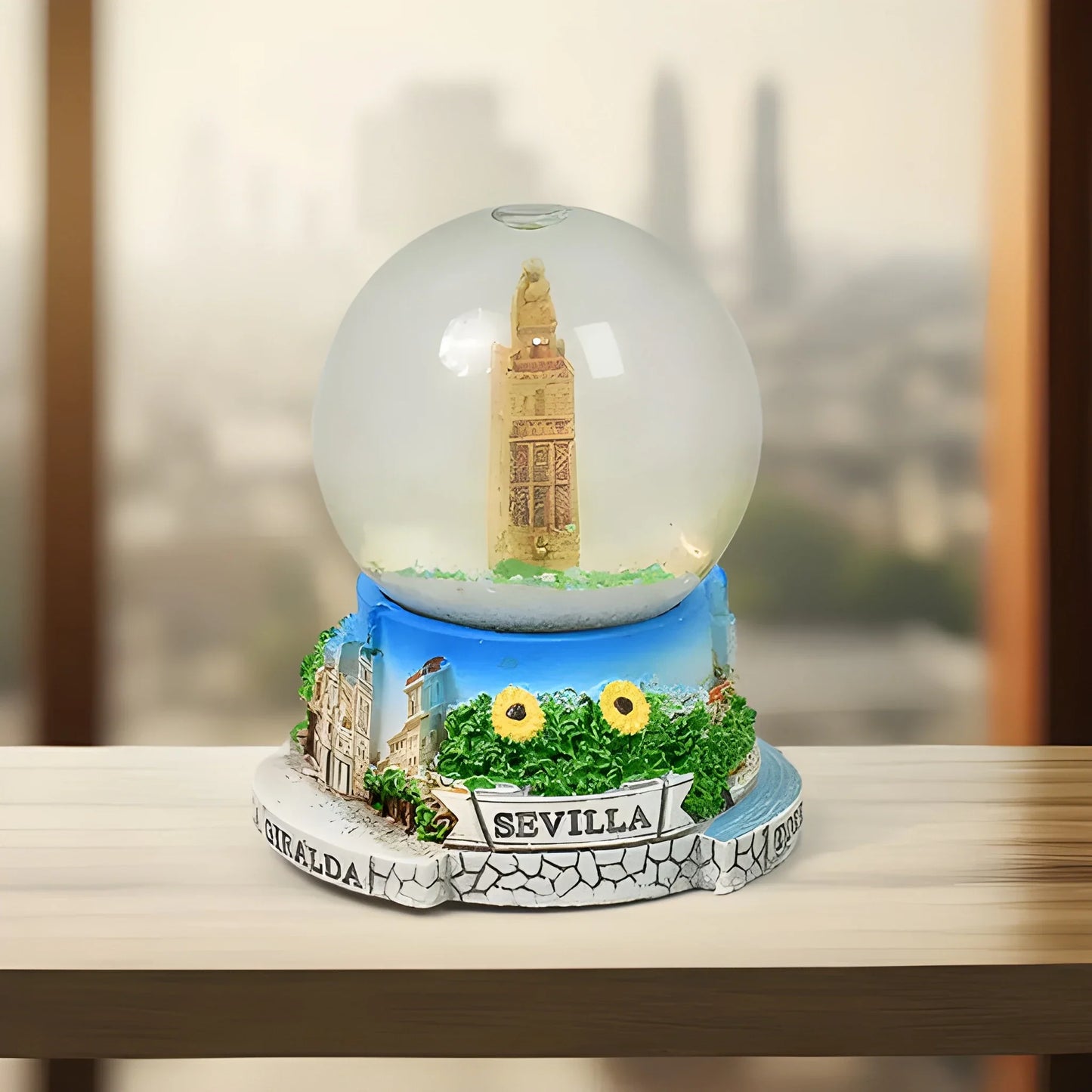 Magical snow globe with glass dome, golden landmark, blue base, SEVILLA label and flowers