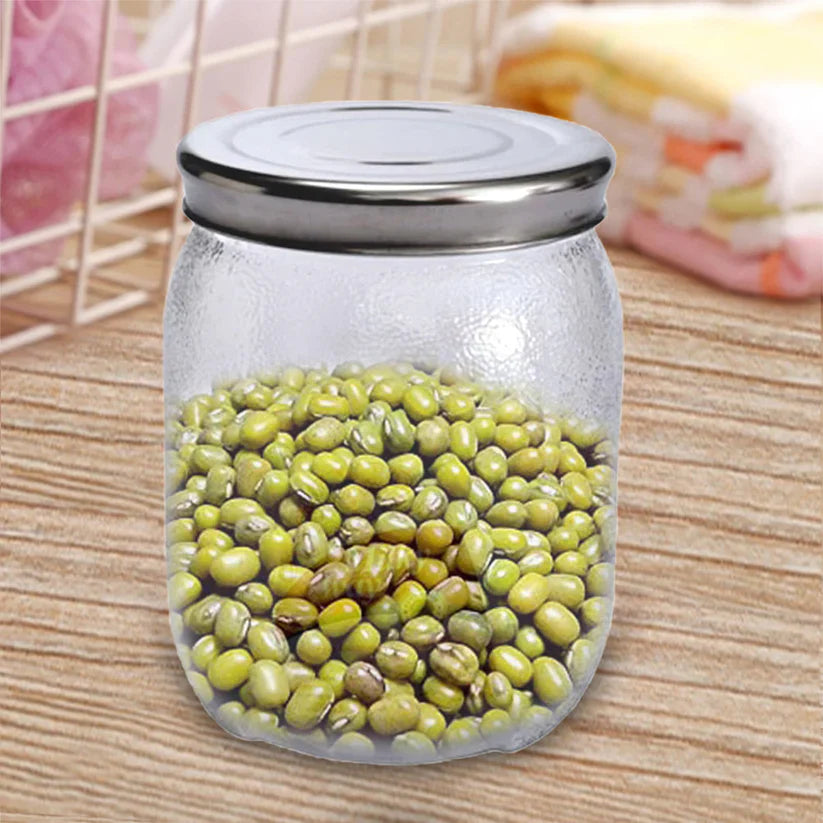 Glass mason jar with metal lid holding green olives