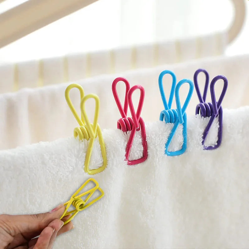 Colorful metal clothespins clipped to white towel, held in hand