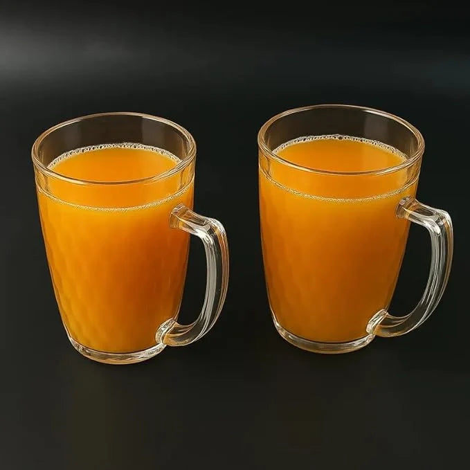 Two glass mug cups with curved handles, filled with amber mocktail