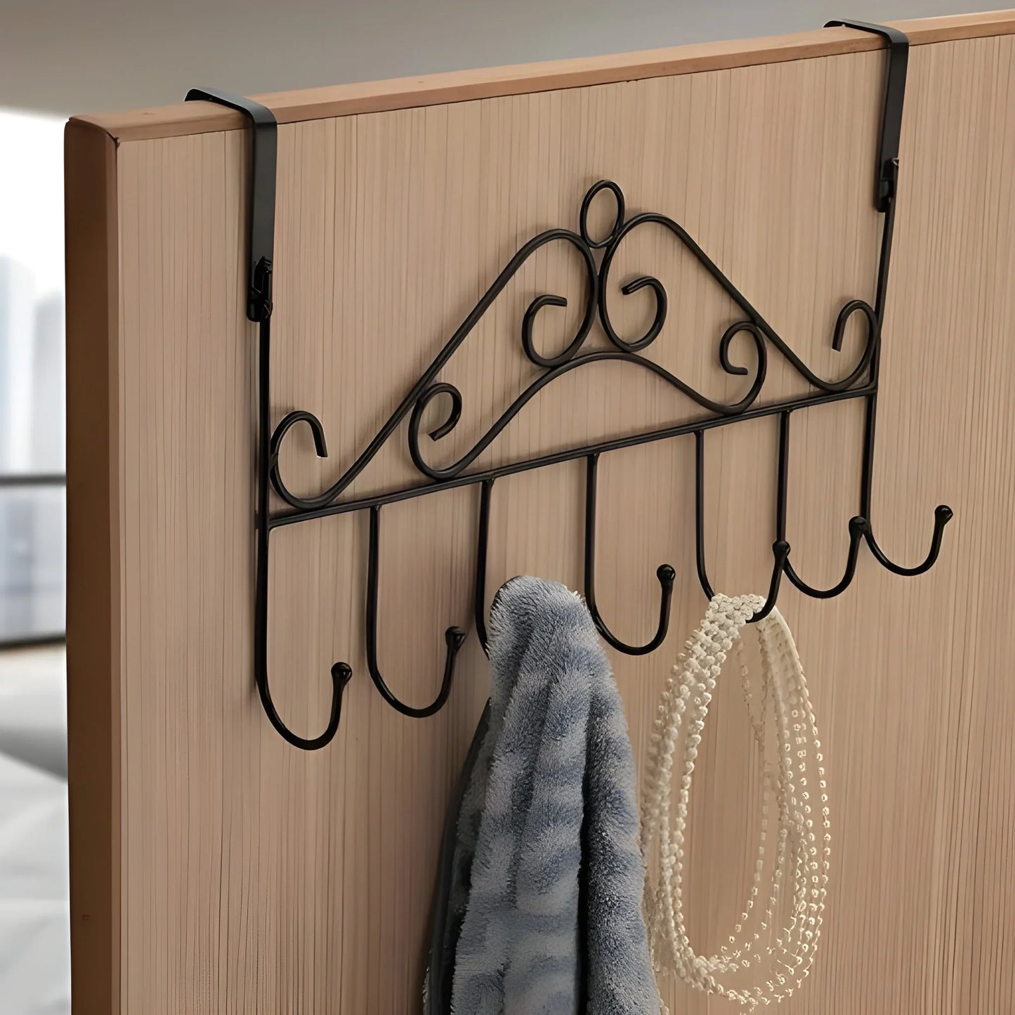 Over-the-door hanger rack with black metal hooks, mounted on a door edge