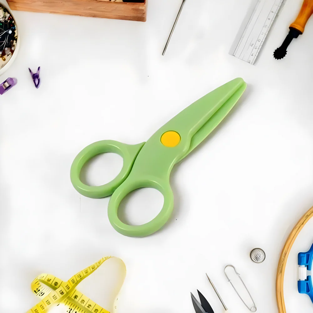 Green plastic safety scissors with rounded finger holes and yellow center button
