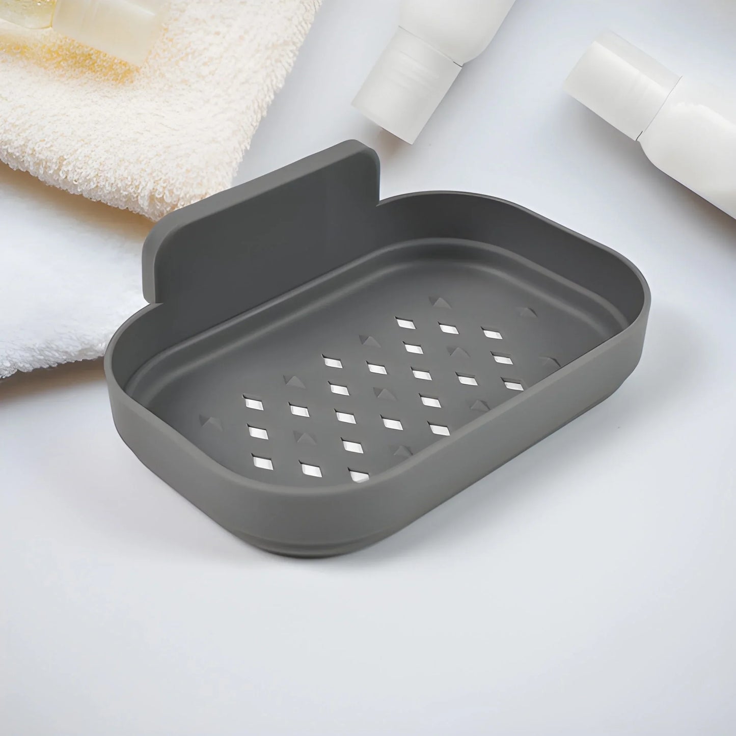 Dark gray soap dish with raised rim and drainage holes