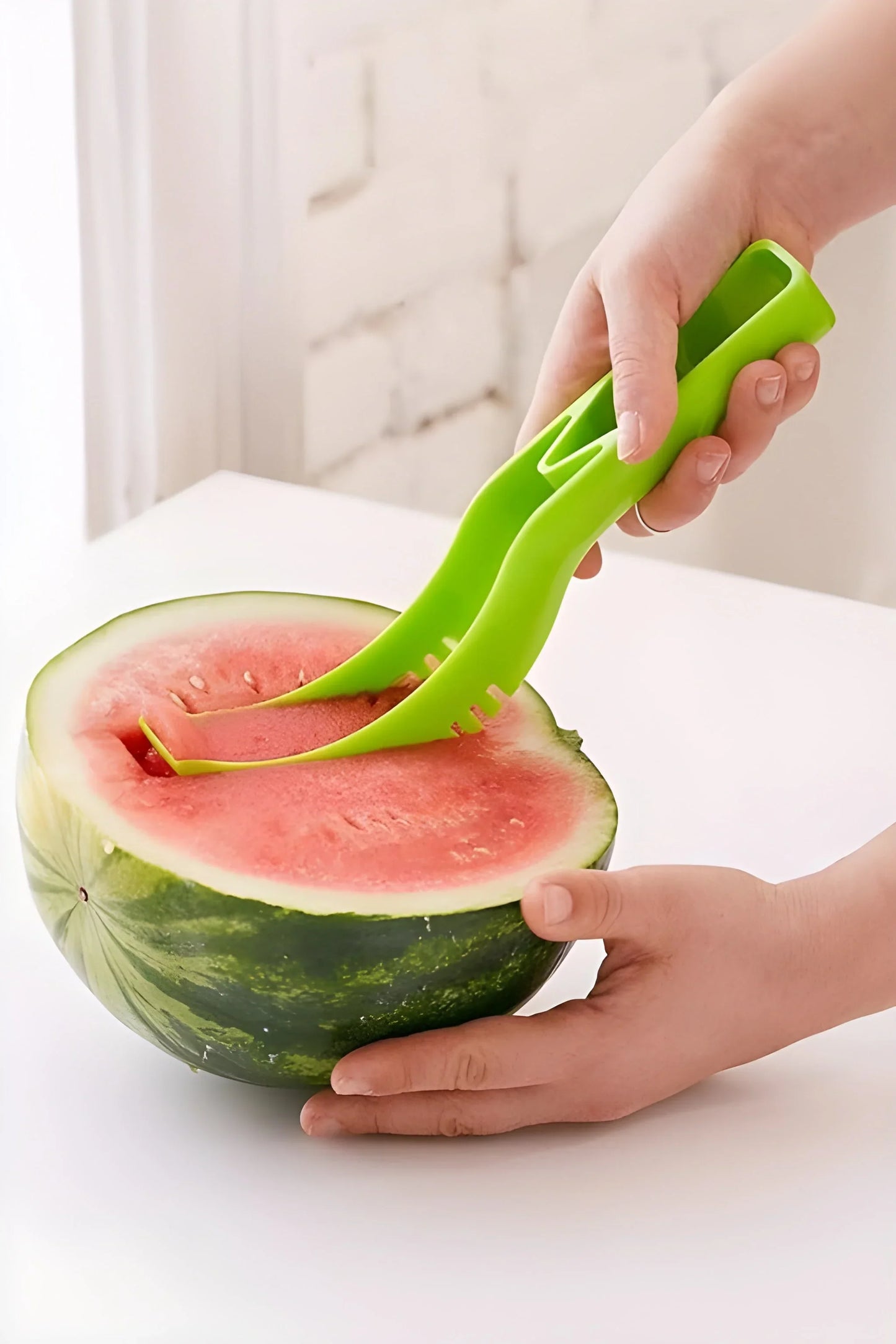 Green watermelon cutter tool slicing a watermelon half