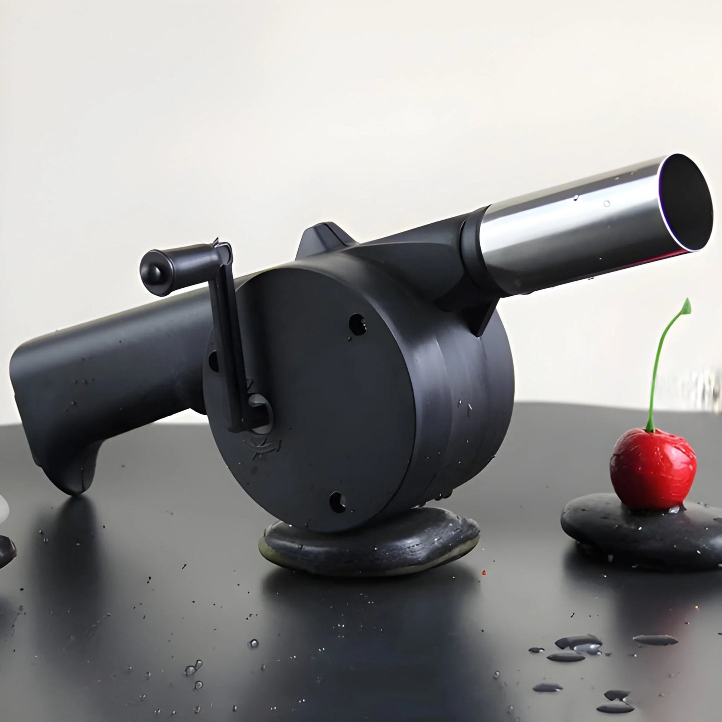 Portable hand crank air blower fan with black nozzle, silver barrel, and crank handle