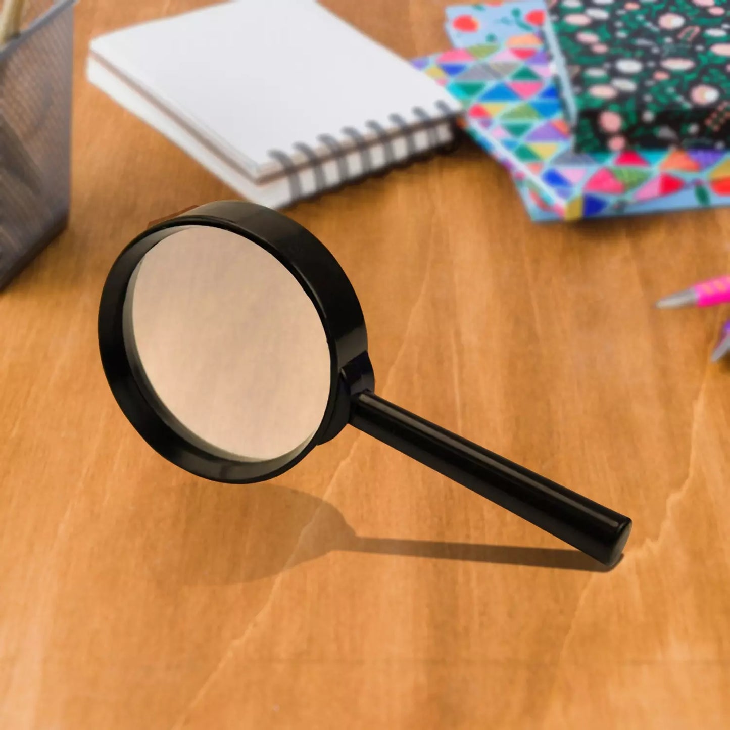 Glass magnifying lens with black frame and long handle