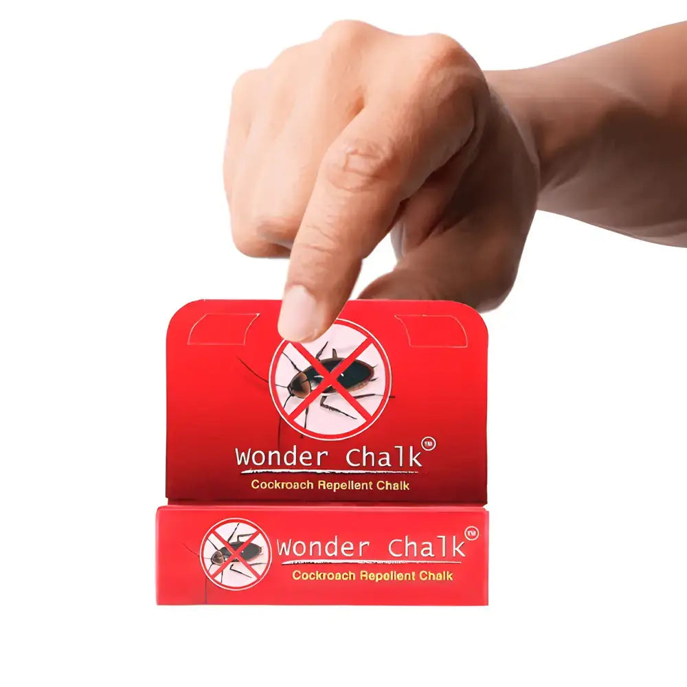 Hand holding Wonder Chalk cockroach repellent chalk sticks, red packaging with roach icon
