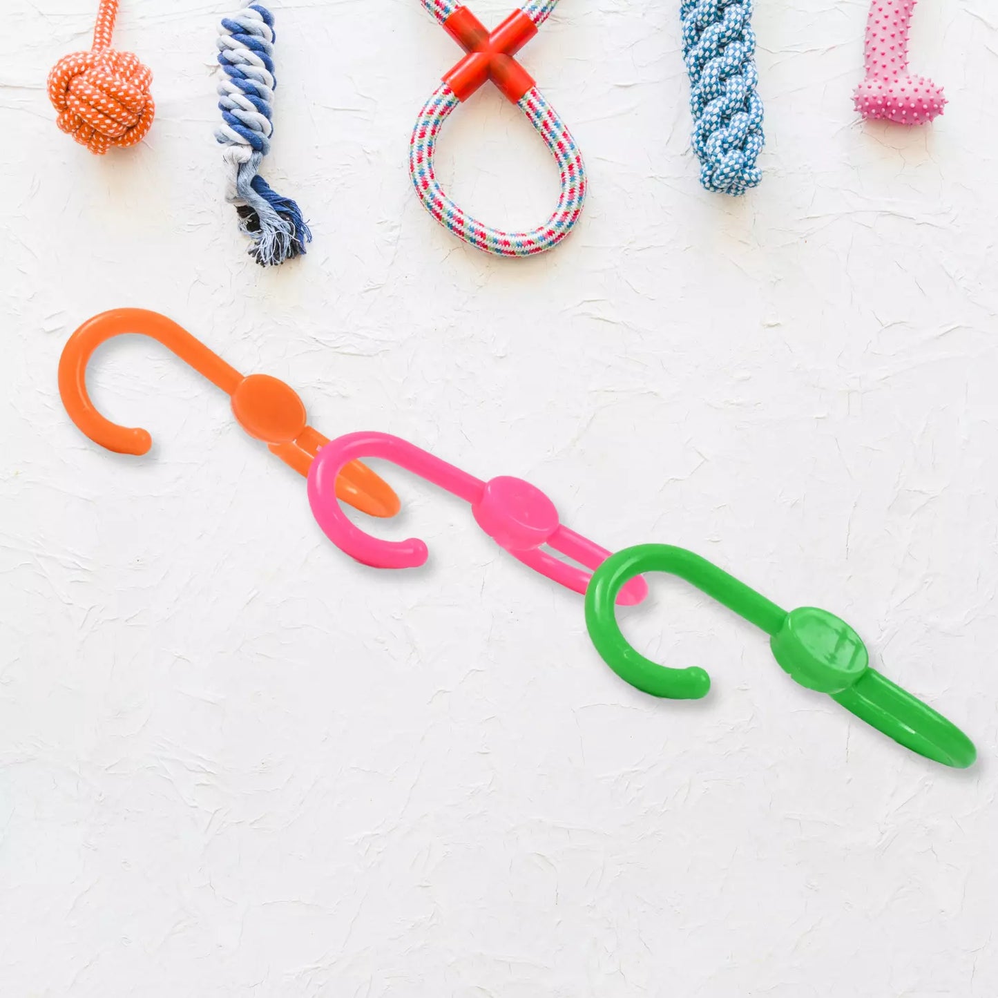 Set of S-shaped plastic hangers in orange, pink, and green with hooks
