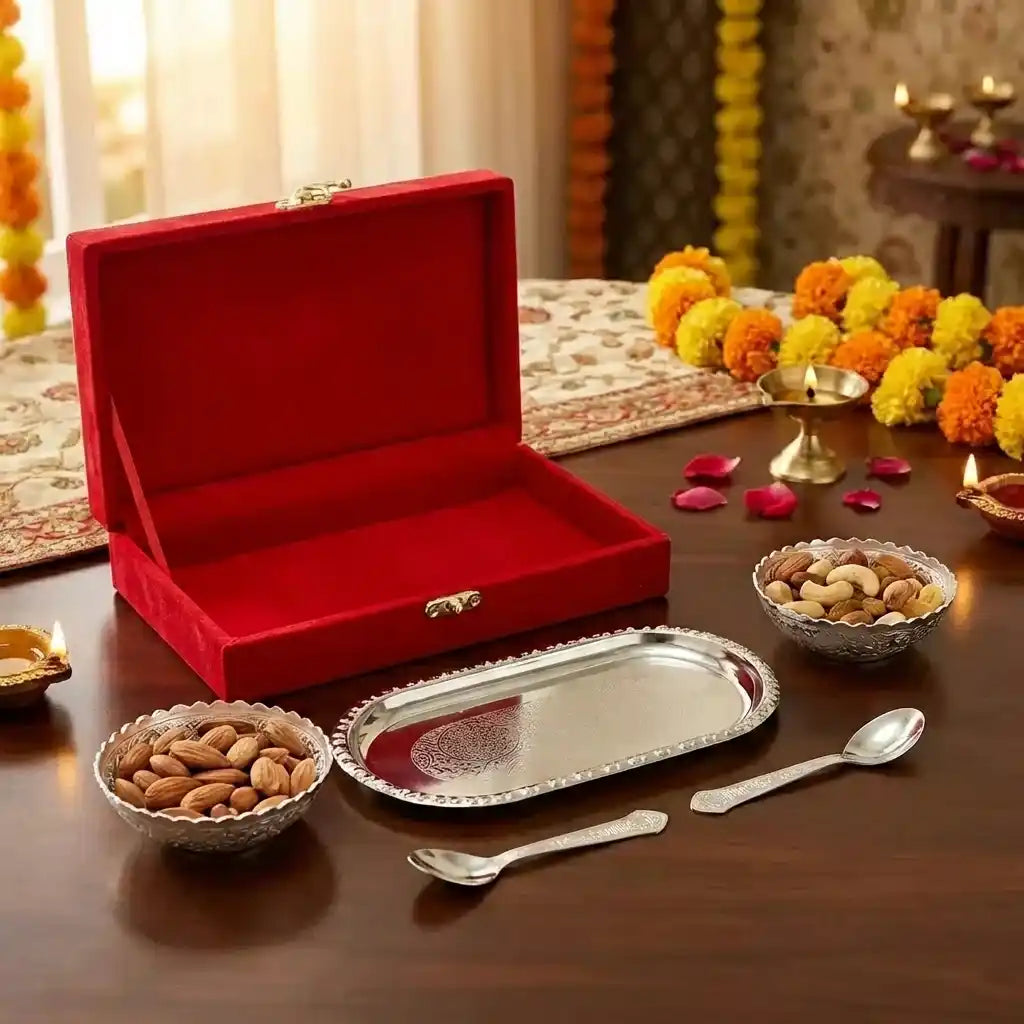 Silver plated bowl set with oval serving tray, two bowls, spoons on tabletop