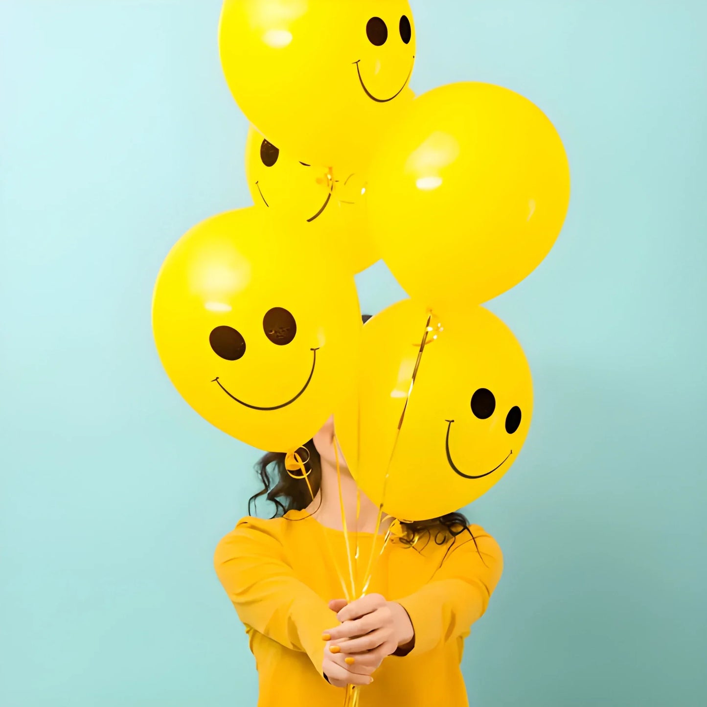 Yellow smiley print party balloons held in a bundle