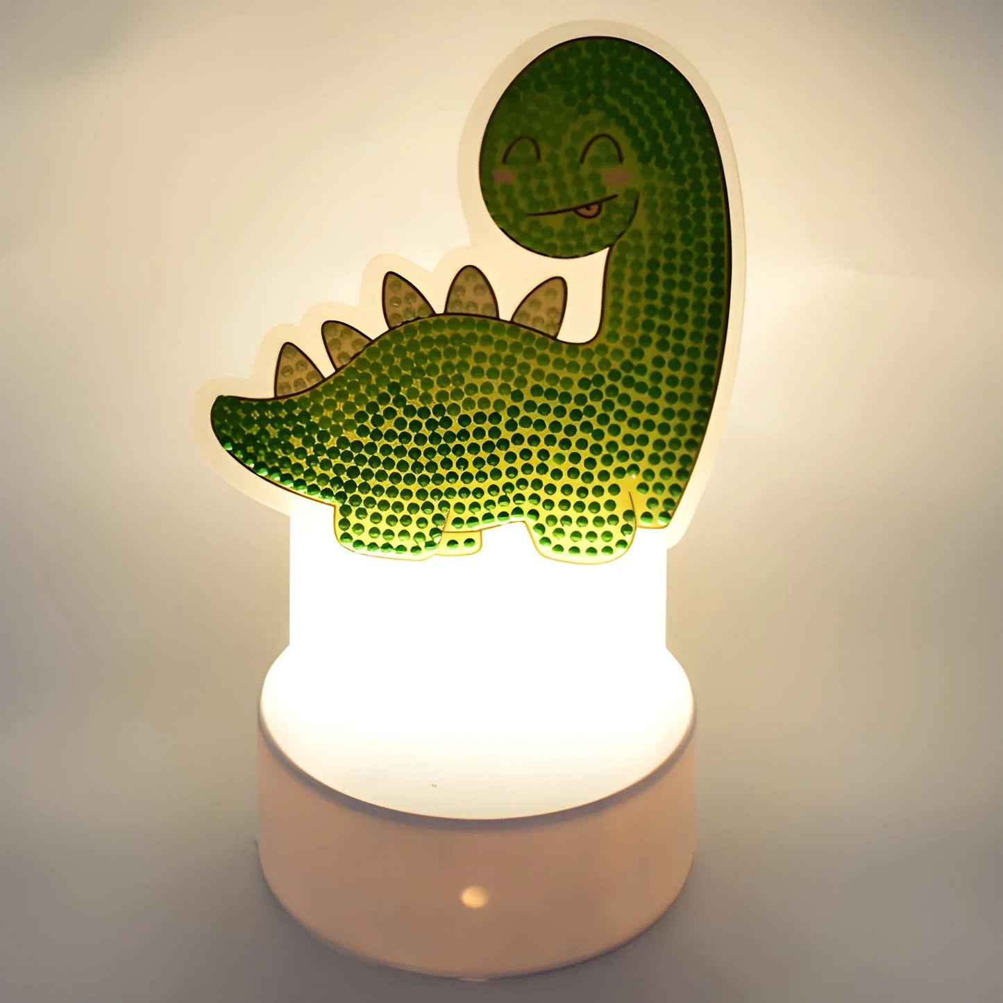 Kids night light with green dino shape on glowing base