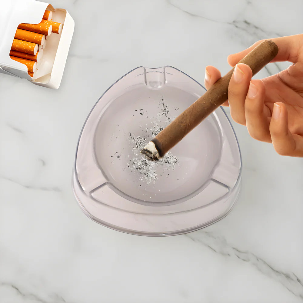 Transparent white glass ashtray with cigar and visible ash on base