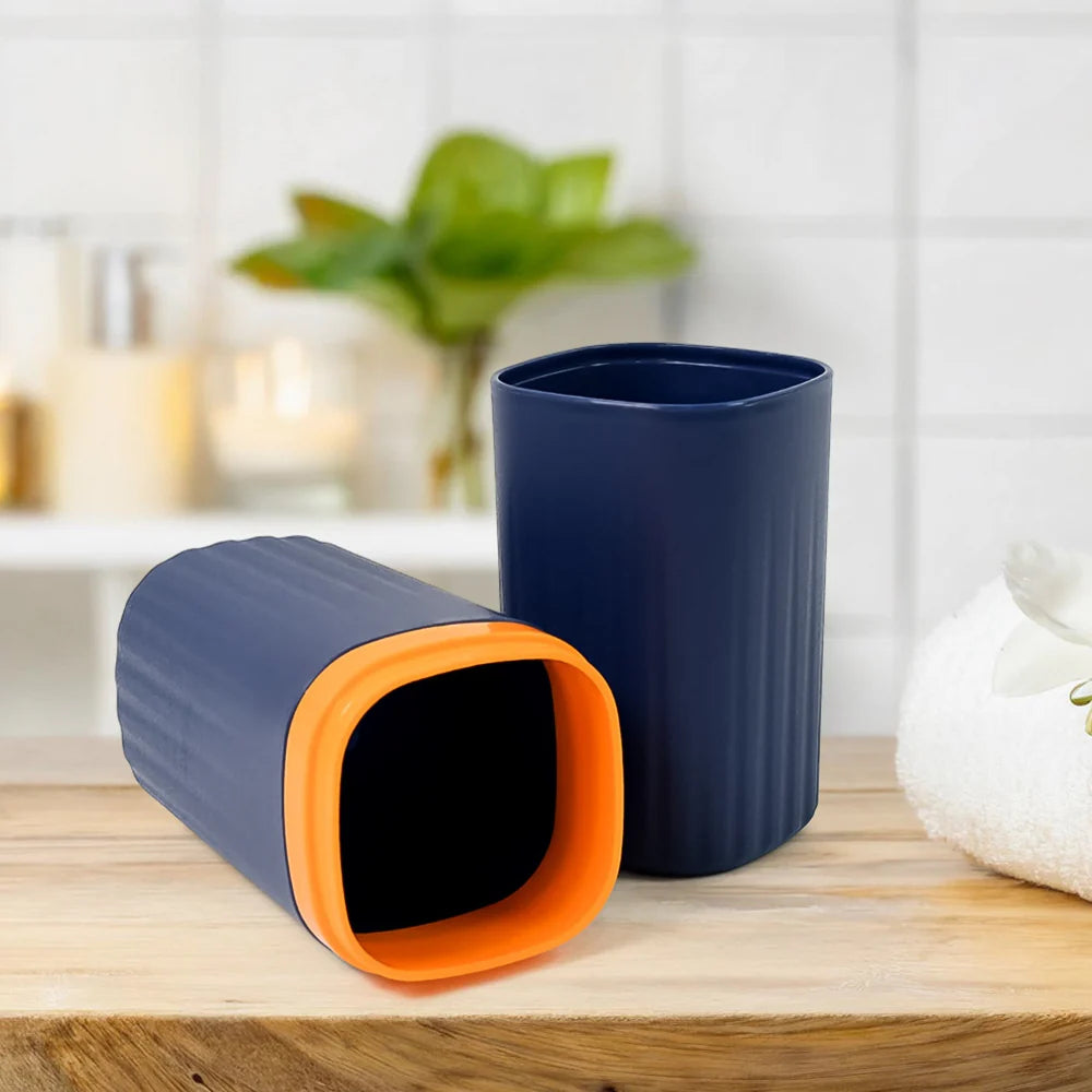 Cylindrical travel toothbrush holder with orange base ring, navy blue body