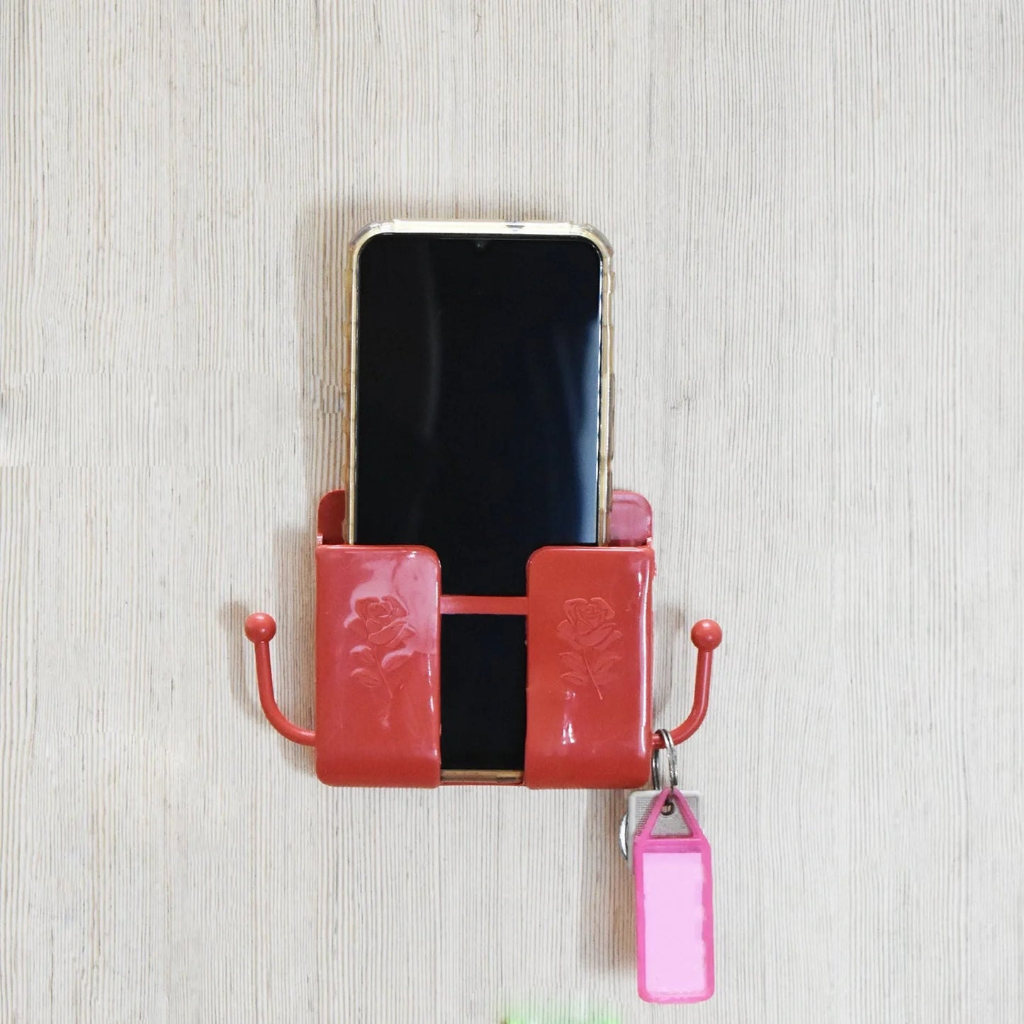 Wall-mounted remote organizer box with pink/red holders, clear window and hanging tag