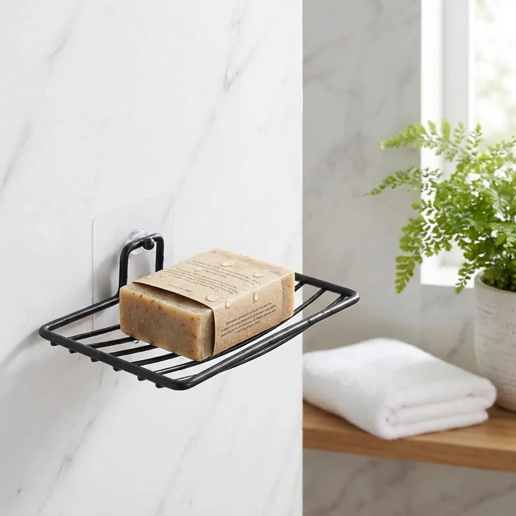 Wall-mounted black metal soap rack with a rectangular bar of soap on top