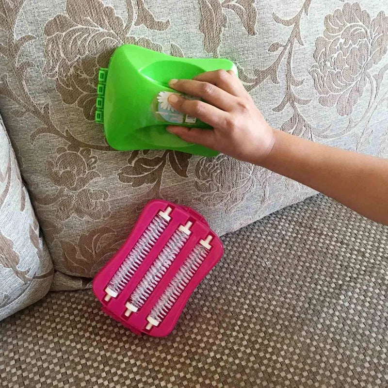 Carpet roller brush with green handle and pink roller head, hand holding it on fabric