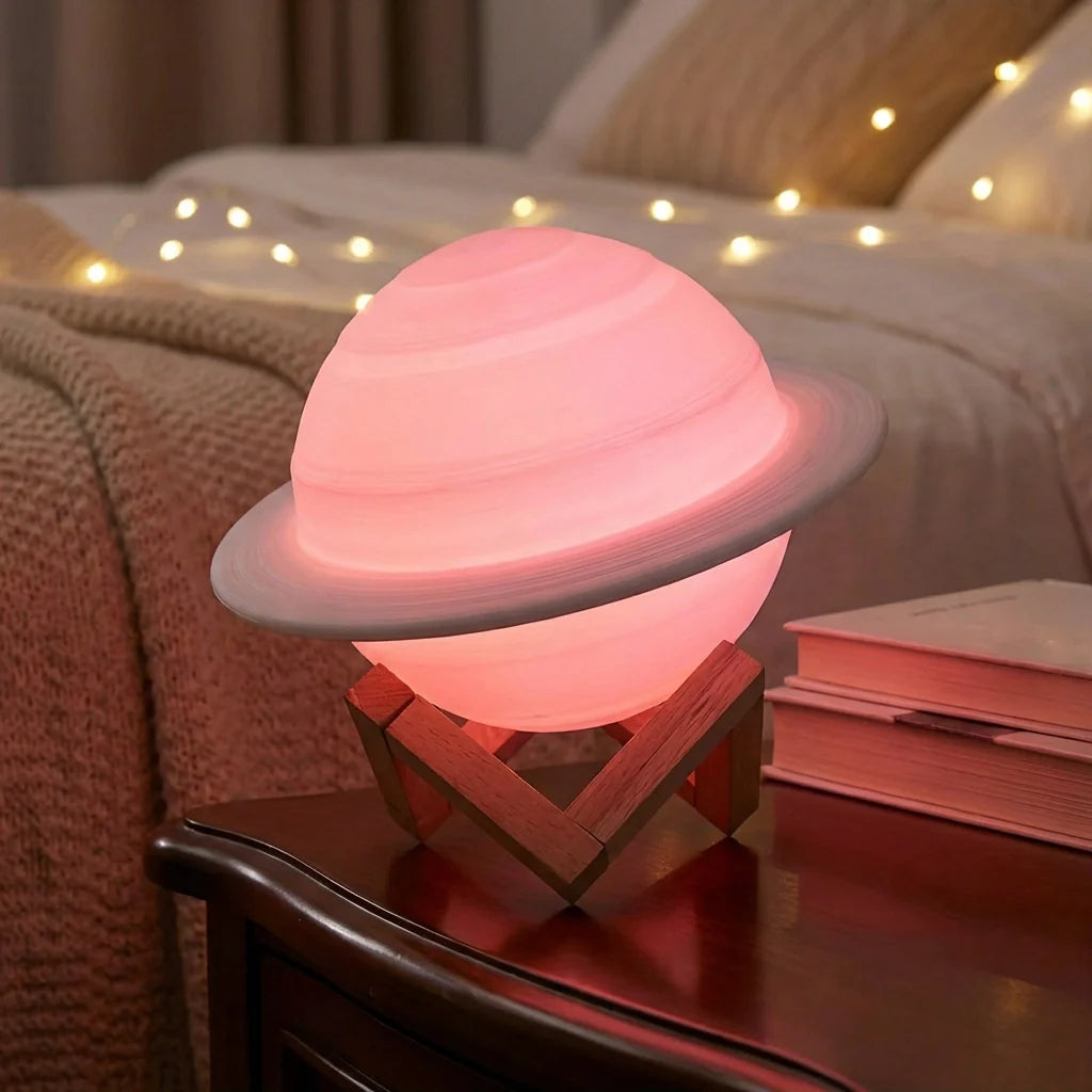 3D Saturn lamp with pink glow on wooden base