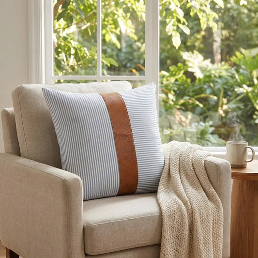 Leather and cotton pillow cover with vertical striped fabric and tan leather trim