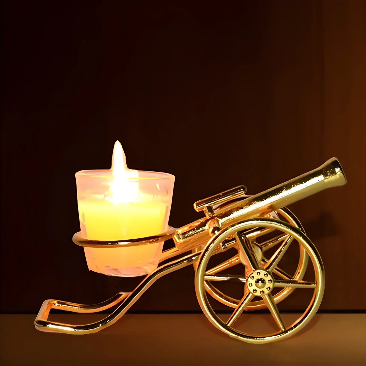Gold cannon-shaped diya holder with lit tealight and front wheel detail