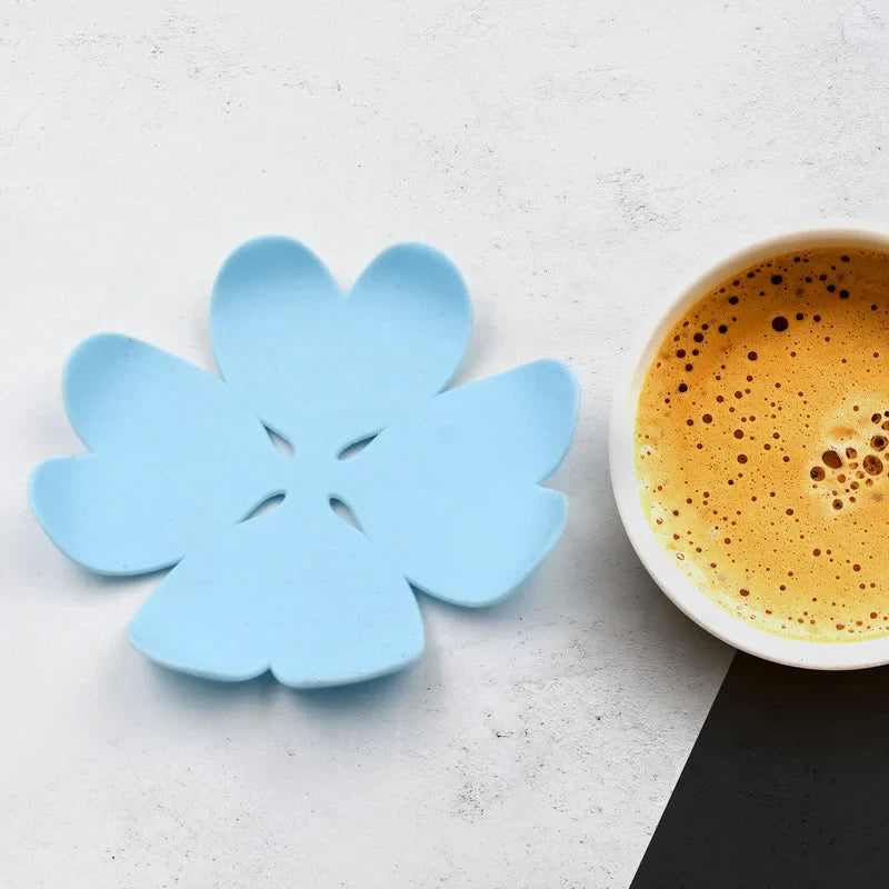 Blue flower-shaped plastic drink coaster with star cutout design