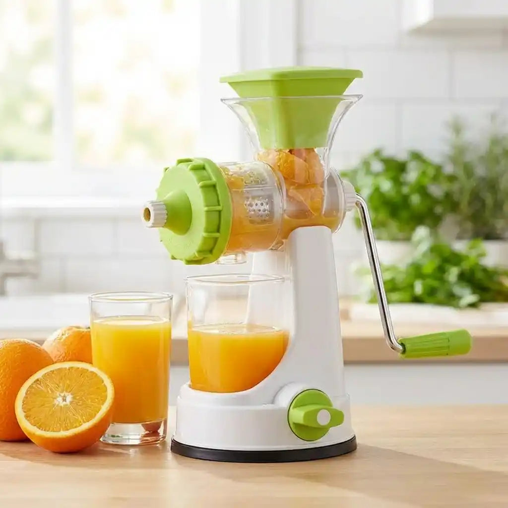 Manual juicer with white base and green hopper beside fresh citrus halves