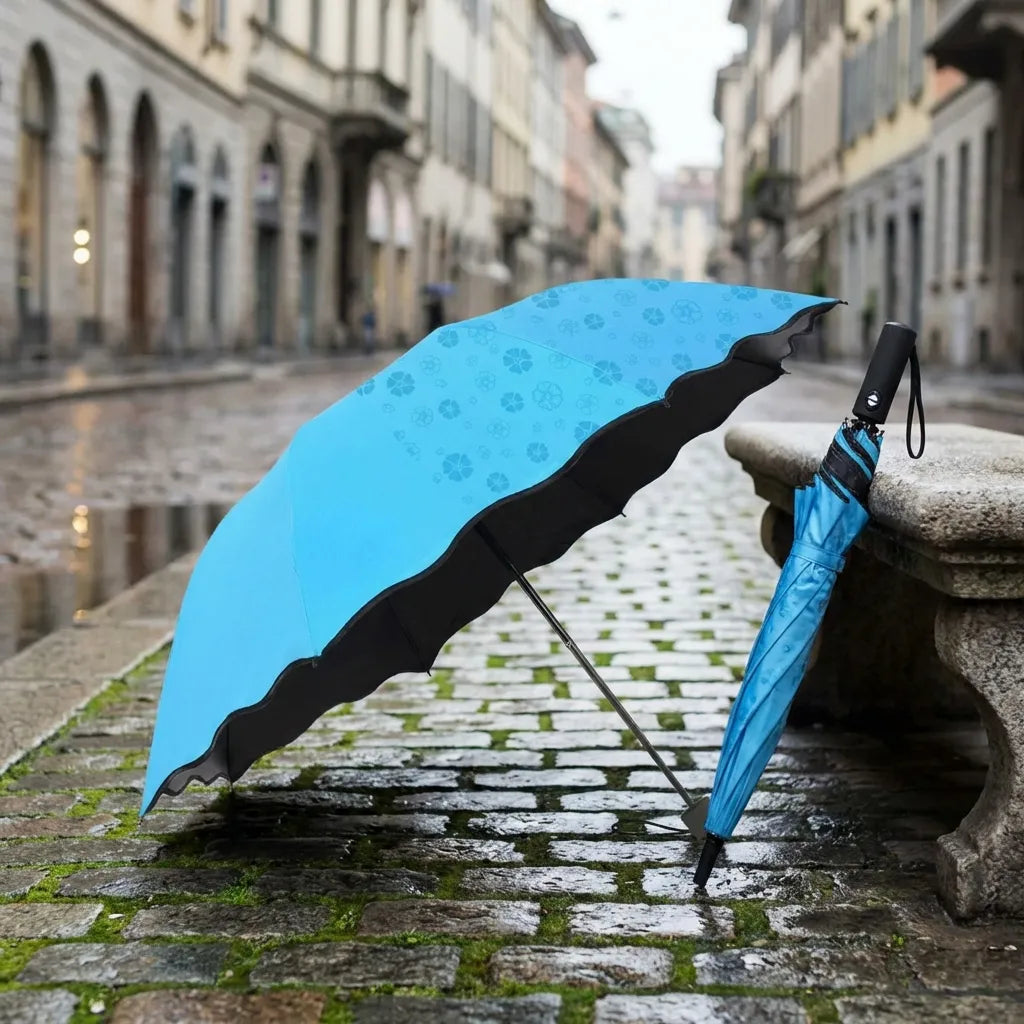 Blue umbrella with flower pattern and black underside trim, leaning open on a ledge