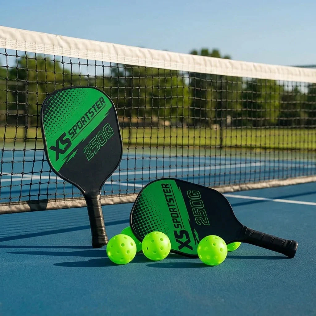 Pickleball paddle set with two paddles and neon green balls beside net