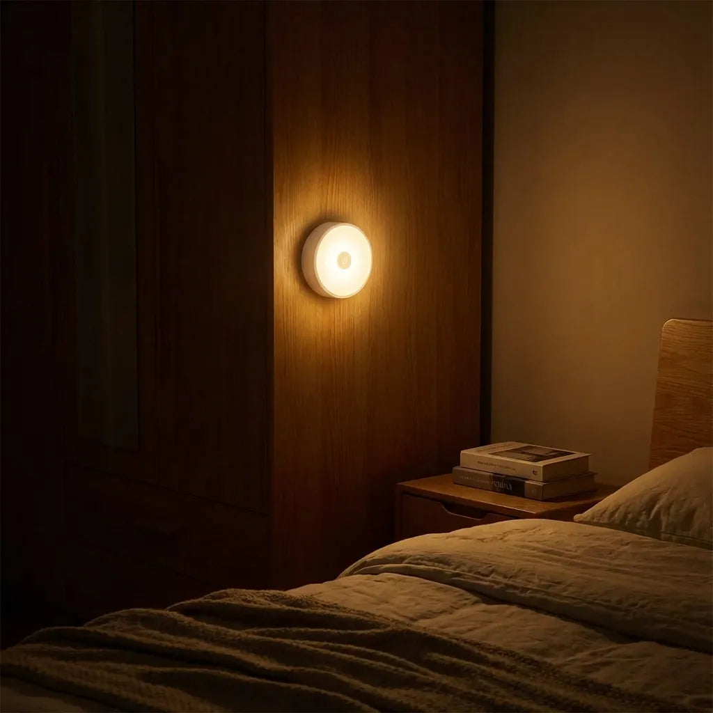 Circular wall night light glowing warm on wooden panel