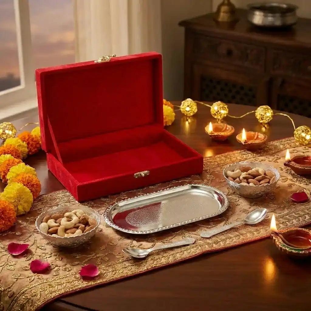 Silver plated serving bowl set with round bowls and spoon, open red gift box on table