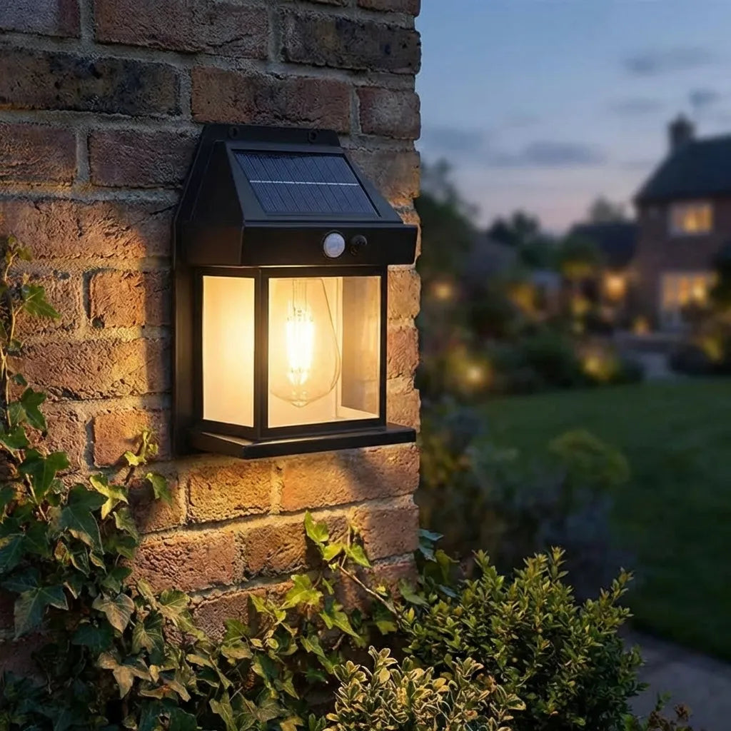 Solar wall lantern light mounted on wall, black frame, solar panel top, glowing bulb
