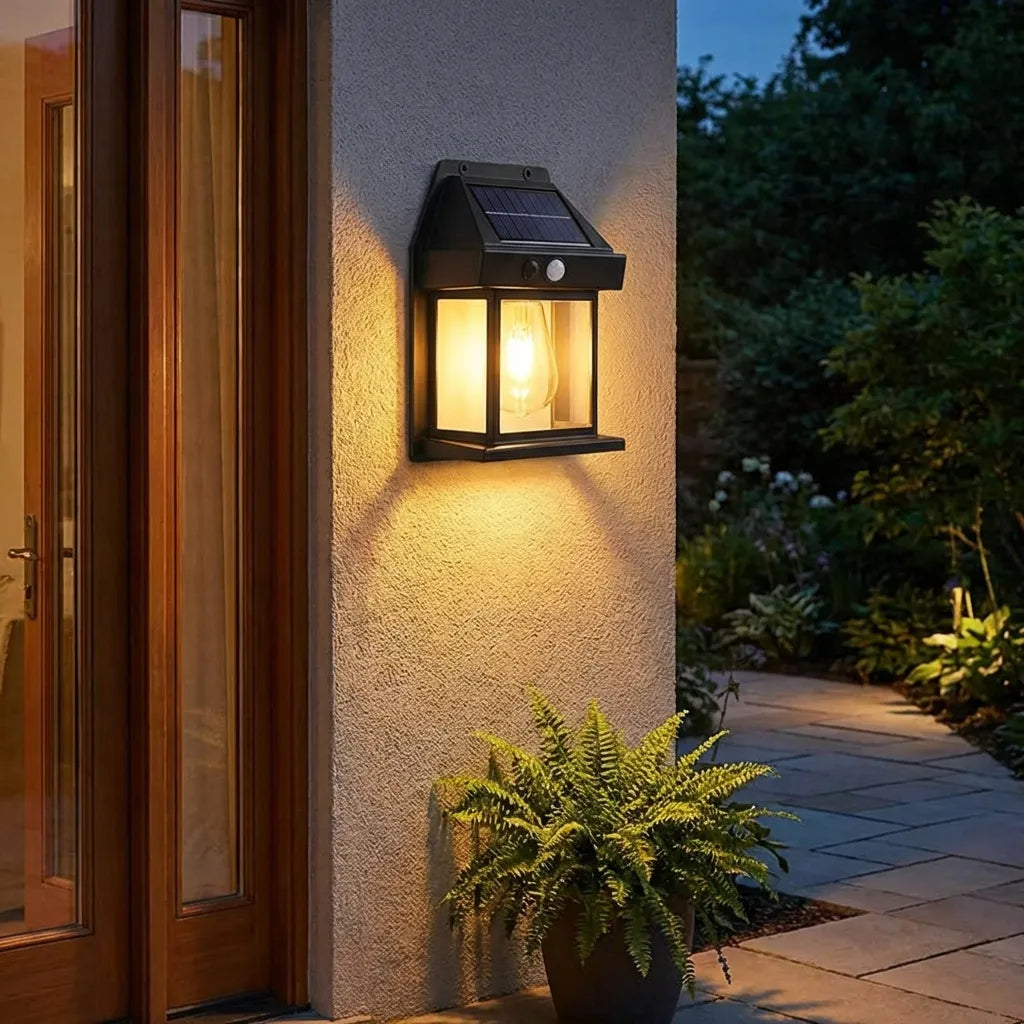 Solar wall lantern light with black metal housing, solar panel top, warm glowing bulb