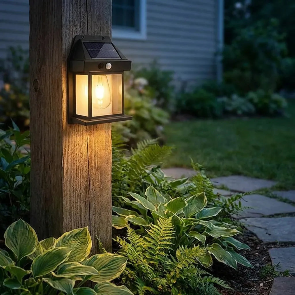 Solar wall lantern light on wooden surface, black housing, solar panel top, glowing bulb