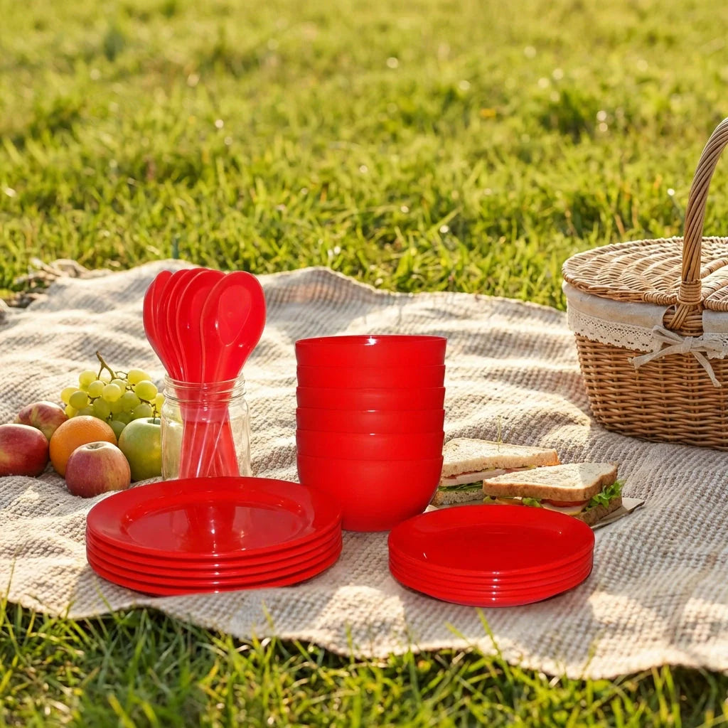 Red soup bowl set with stack of bowls and matching plates, picnic-ready table setting