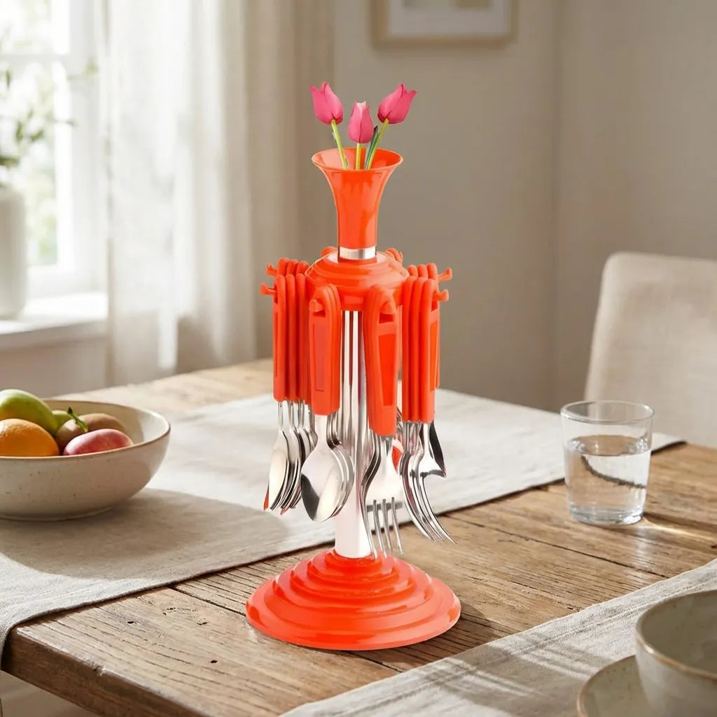 Stainless cutlery set with an orange base and metal forks and spoons, flower vase in the center.