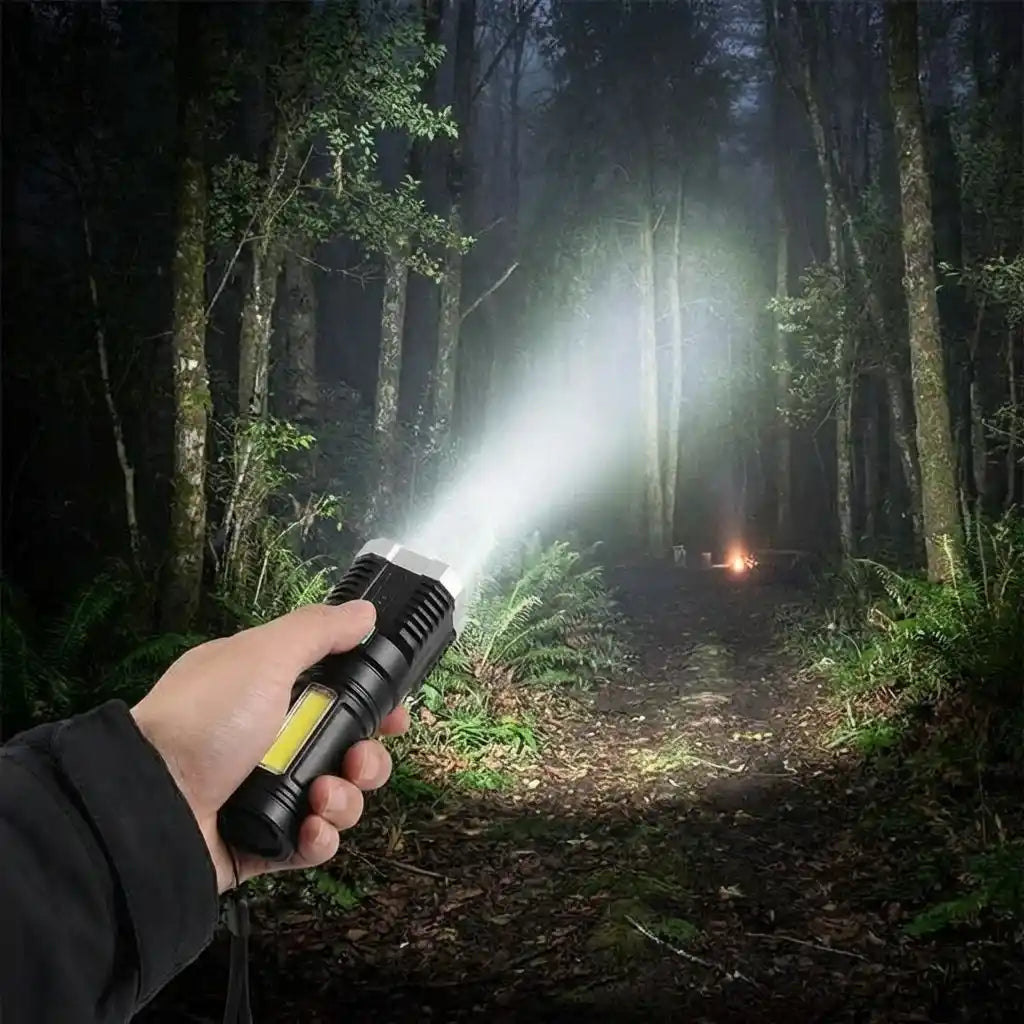 Hand gripping black LED torch light, front emitting strong white beam