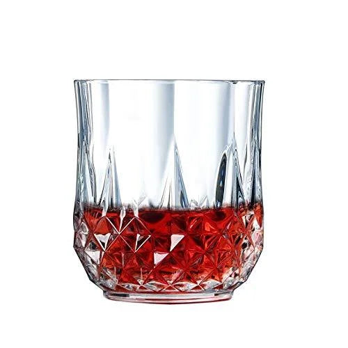 Faceted transparent drinking glass with red tinted lower section and diamond pattern